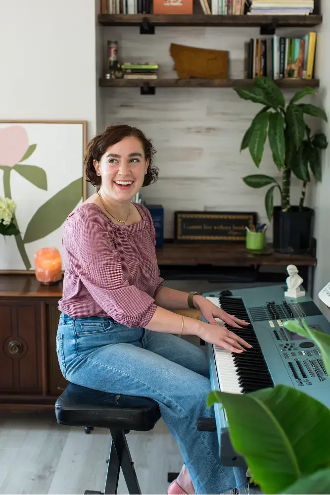 Woman sitting at a digital piano keyboard