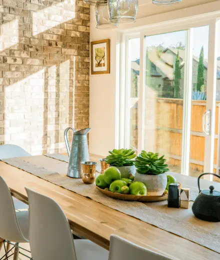 A dining table with sunlight coming in from a patio door